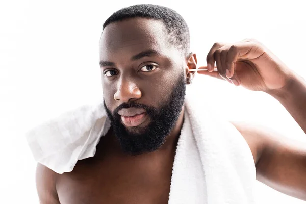 Porträt eines afroamerikanischen Mannes, der mit Ohrstöpsel Ohren putzt — Stockfoto
