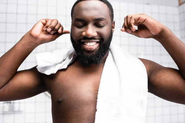 Retrato de hombre afro-americano limpiando orejas con placer - foto de stock