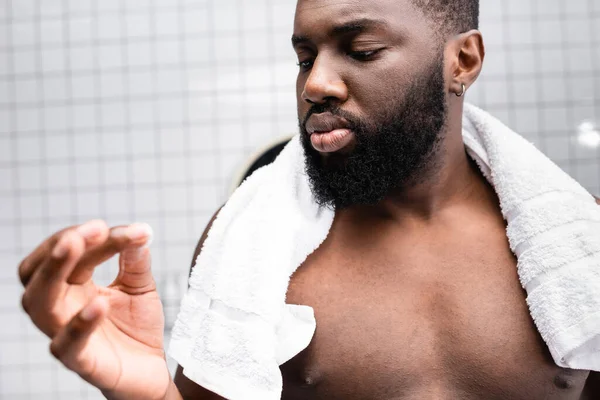 Homme afro-américain utilisant un remède pour renforcer la croissance de la barbe — Photo de stock