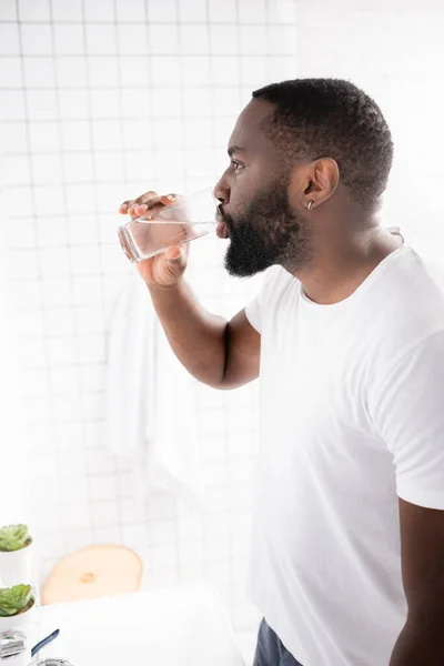 Vista lateral del hombre afroamericano agua potable — Stock Photo
