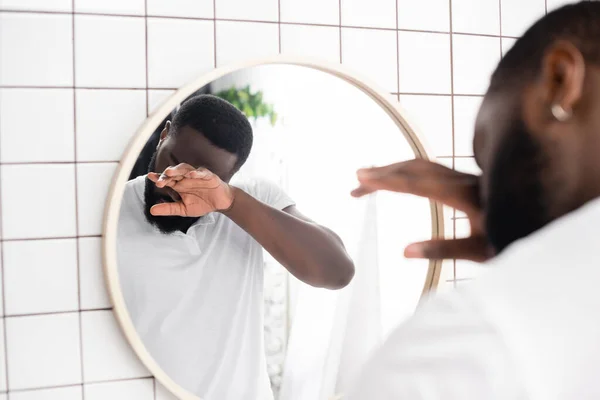 Hombre afro-americano frotando los ojos con la mano - foto de stock