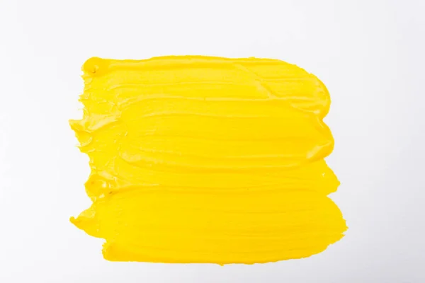 Vista superior de pinceladas abstractas de color amarillo sobre fondo blanco - foto de stock