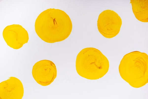 Vista superior de los círculos pintados de color amarillo abstracto sobre fondo blanco - foto de stock