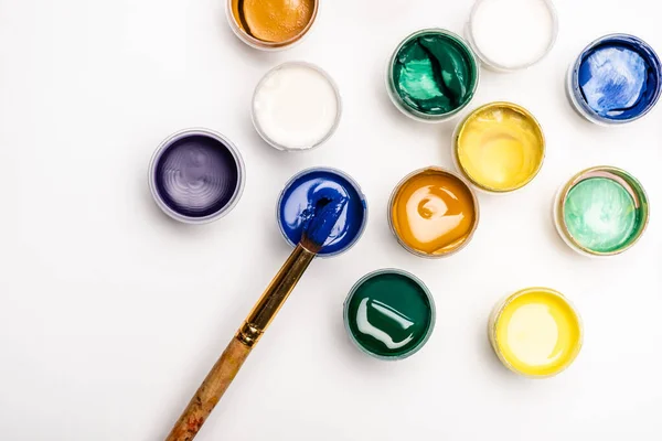 Vue du dessus des peintures et pinceau Gouache sur fond blanc — Photo de stock
