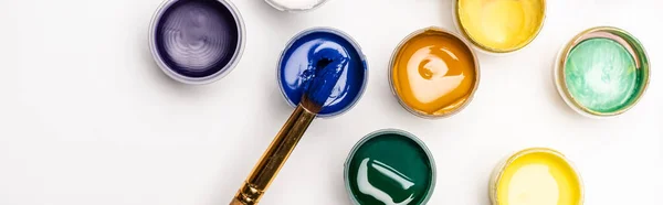 Top view of colorful Gouache paints and paintbrush on white background, panoramic shot — Stock Photo