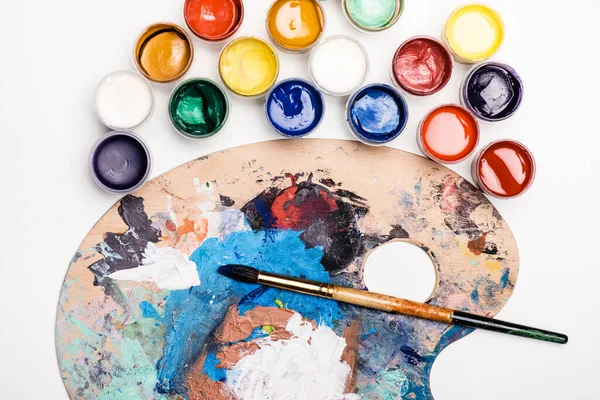 Vue du dessus de la palette avec peintures Gouache et pinceau sur fond blanc — Photo de stock