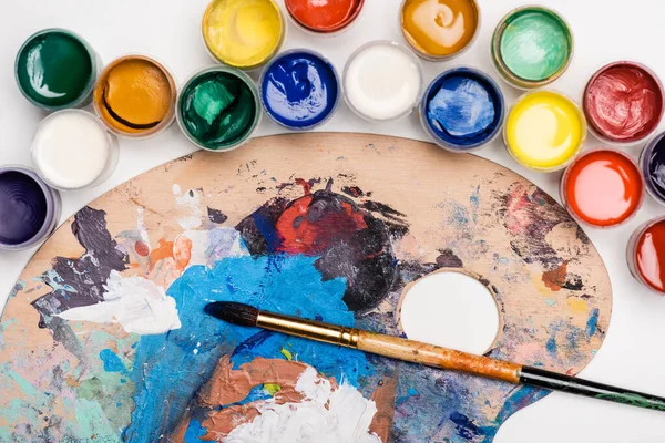 Vue du dessus de la palette avec peintures Gouache et pinceau sur fond blanc — Photo de stock