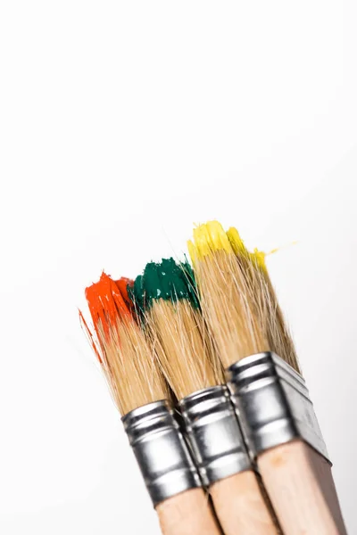 Top view of paintbrushes with colorful paint on white background — Stock Photo