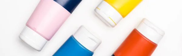 Vue de dessus des tubes de peinture acrylique sur fond blanc, panoramique — Photo de stock