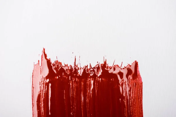 Top view of colorful red paint brushstroke on white background — Stock Photo