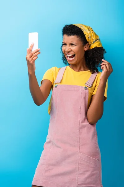 Riccio africano americano donna urlando mentre prende selfie su blu — Foto stock