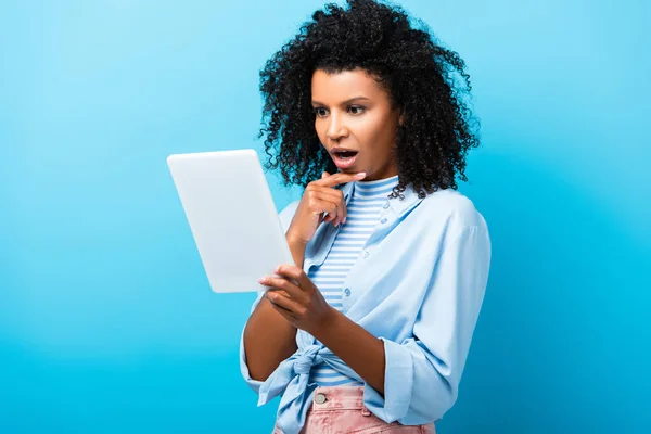 Chocado afro-americano mulher usando tablet digital em azul — Fotografia de Stock