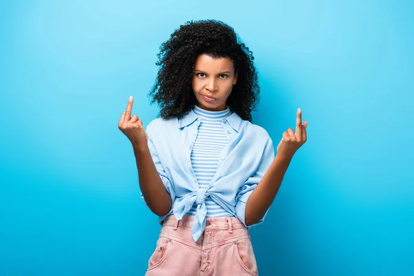 Unzufriedene afrikanisch-amerikanische Frau zeigt Mittelfinger auf blau — Stockfoto