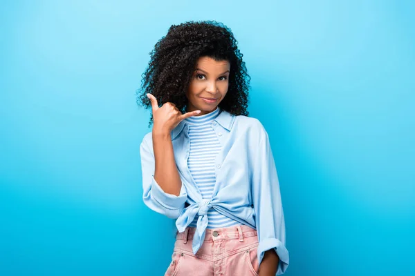 Afro americano donna mostrando chiamata me segno su blu — Foto stock