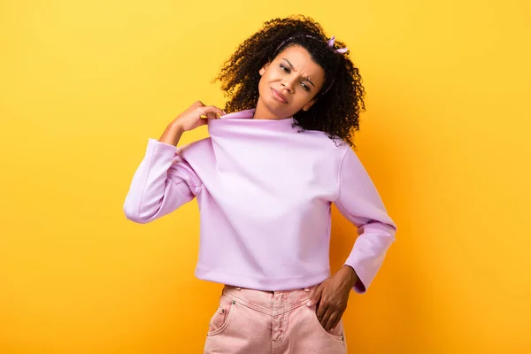 Curly african american woman suffering from heat on yellow — Stock Photo