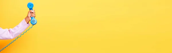 Vista cortada da mulher americana africana segurando telefone retro azul no amarelo, banner — Fotografia de Stock
