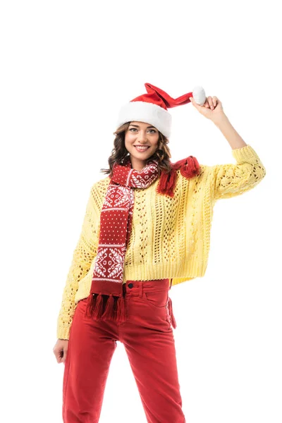 Радісна молода жінка в шарфі торкається капелюха Санта ізольована на білому — стокове фото