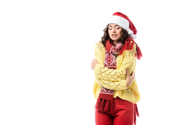 Young freezing woman in santa hat and scarf standing isolated on white — Stock Photo