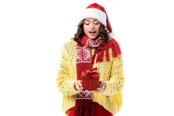 Donna eccitata in cappello di Babbo Natale e sciarpa rossa guardando al presente isolato su bianco — Foto stock