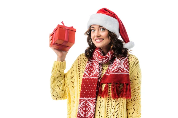 Aufgeregte junge Frau in Weihnachtsmütze und Schal mit Geschenk auf weißem Grund — Stockfoto