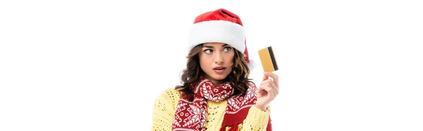 Panoramic crop of woman in santa hat and scarf holding credit card isolated on white — Stock Photo
