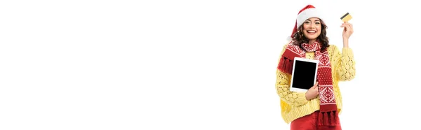Conceito panorâmico de mulher alegre em santa hat e lenço segurando tablet digital com tela em branco e cartão de crédito isolado em branco — Fotografia de Stock