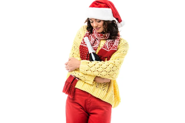 Junge Frau mit Weihnachtsmütze und Schal mit Ornament, die eine Flasche Champagner auf weißem Grund hält — Stockfoto