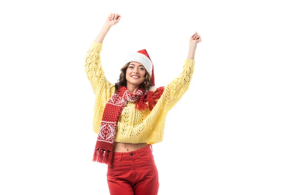 Junge glückliche Frau mit Weihnachtsmütze und rotem Schal, die Hände über dem Kopf isoliert auf weißem Grund stehend — Stockfoto