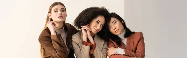 Pretty interracial women in pastel formal wear posing on white, banner — Stock Photo