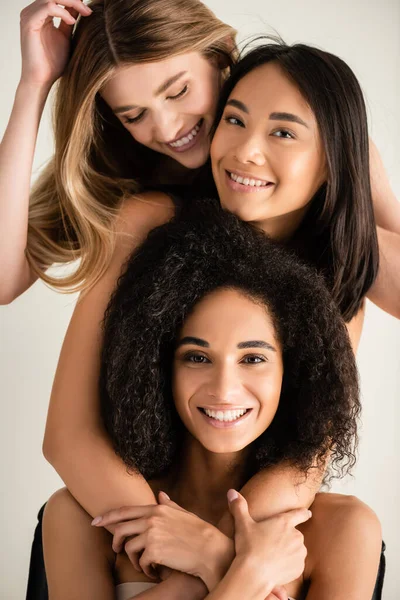 Jóvenes modelos multiculturales sonriendo aislados en blanco - foto de stock