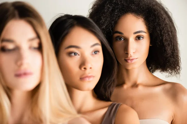 African american woman near multicultural models on blurred foreground — Stock Photo