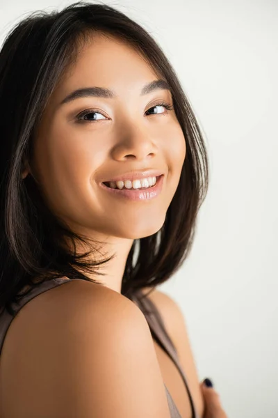 Morena ásia mulher sorrindo enquanto olhando para câmera isolado no branco — Fotografia de Stock