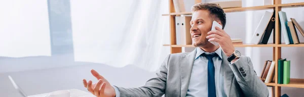 Веселий бізнесмен розмовляє на смартфоні в офісі, банер — стокове фото