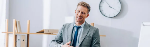 Hombre de negocios positivo sonriendo a la cámara en la oficina, pancarta - foto de stock