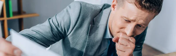 Disappointed businessman looking at paper on blurred foreground, banner — Stock Photo