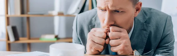 Concentrated businessman looking at cup on blurred foreground in office, banner — Stock Photo