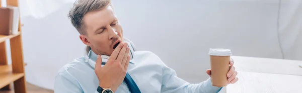 Businessman yawning while holding coffee to go in office, banner — Stock Photo