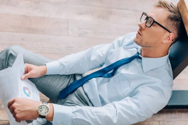 High angle view of businessman with papers sleeping on floor — Stock Photo