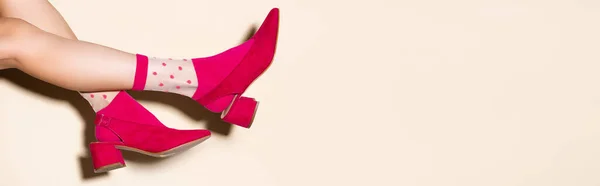 Cropped view of female legs in pink retro socks and shoes on beige background, banner — Stock Photo