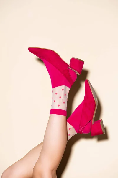 Обрезанный вид женских ног в розовых носках ретро и обуви на бежевом фоне — стоковое фото