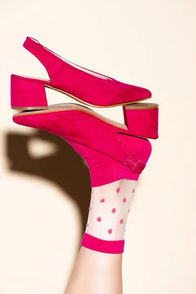 Cropped view of female leg in pink retro socks and shoes on beige background — Stock Photo