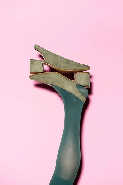 Cropped view of female leg in green tights and retro shoes on lilac background — Stock Photo