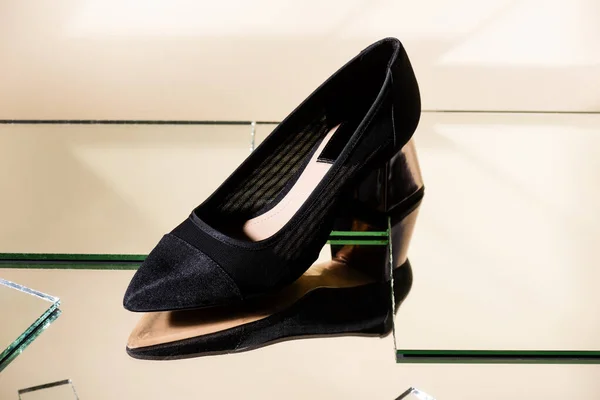 Elegante scarpa con tacco nero sulla superficie dello specchio — Foto stock