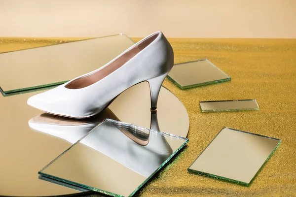 Elegant white heeled shoe on mirror surface — Stock Photo