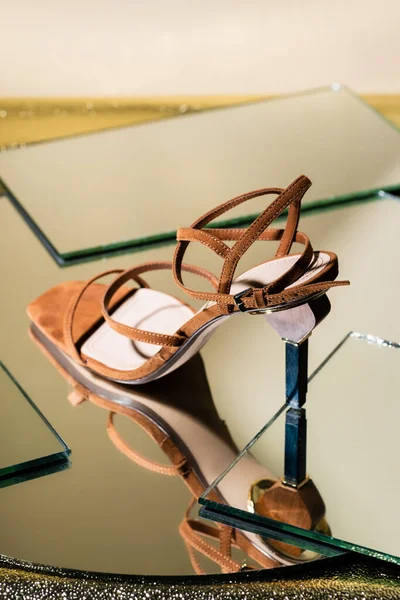 Коричневые замшевые элегантные сандалии на каблуках на зеркальной поверхности — стоковое фото