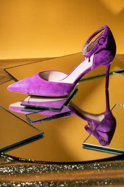 Elegante sapato de salto de camurça violeta na superfície do espelho no fundo amarelo — Fotografia de Stock