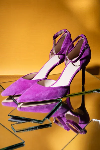 Elegante violette Wildlederschuhe auf Spiegel auf gelbem Hintergrund — Stockfoto