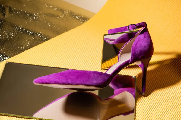 Elegante sapato de salto de camurça violeta no espelho no fundo amarelo — Fotografia de Stock