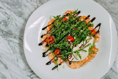 karides, peynir ve roka salatası mermer bir masada beyaz bir tabakta