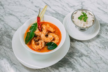Tom yum karides ve pirinç mermer bir masada beyaz bir tabakta